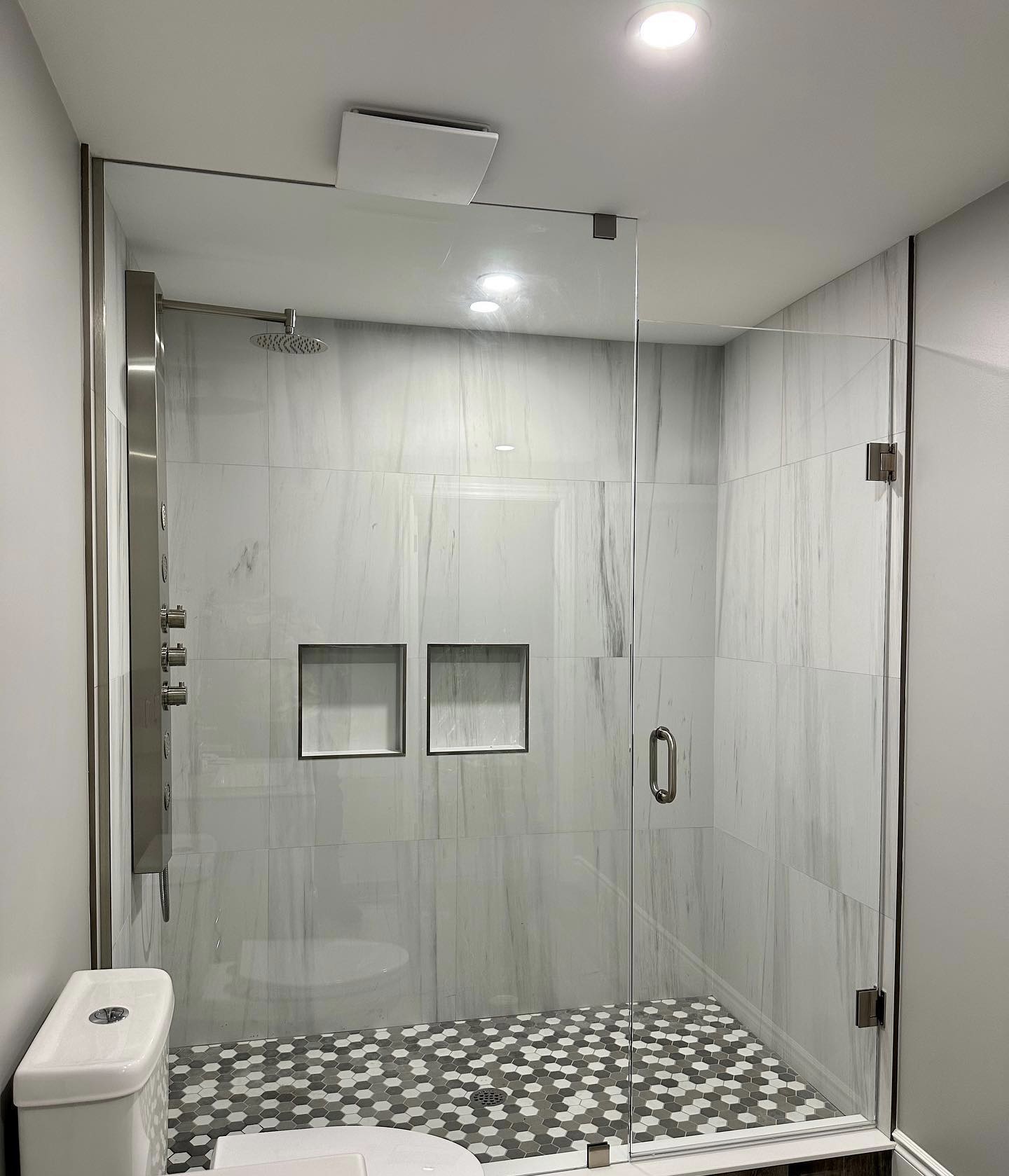 R&B project: frameless glass shower with two wall niches and a pebble floor