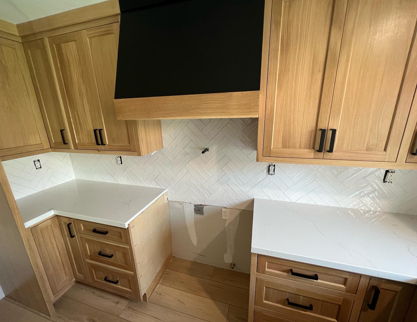 R&B project: light oak cabinets on an L-shaped counter with a black range hood