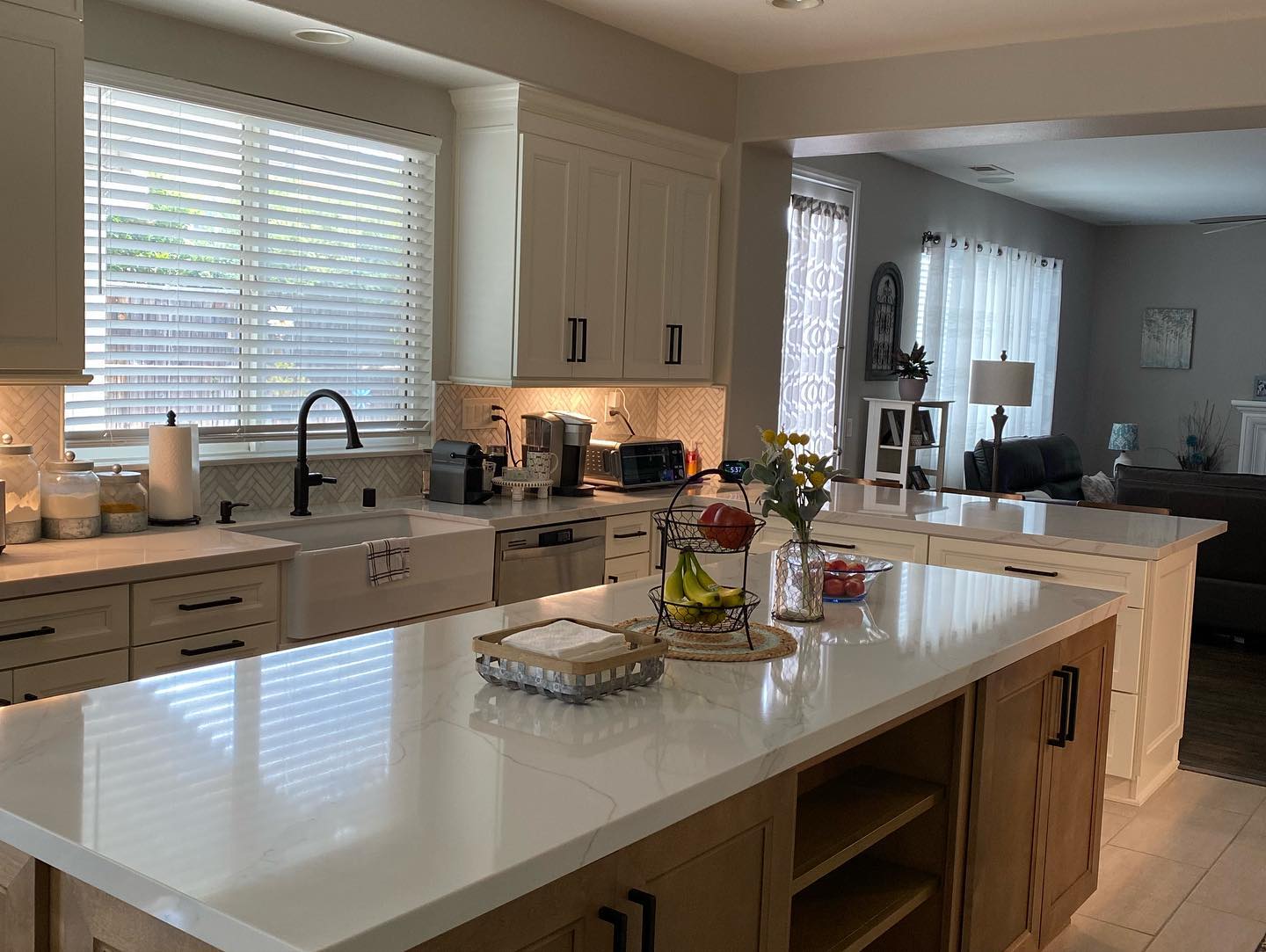 R&B project: white quartz island on wood base cabinets with the sink under a window