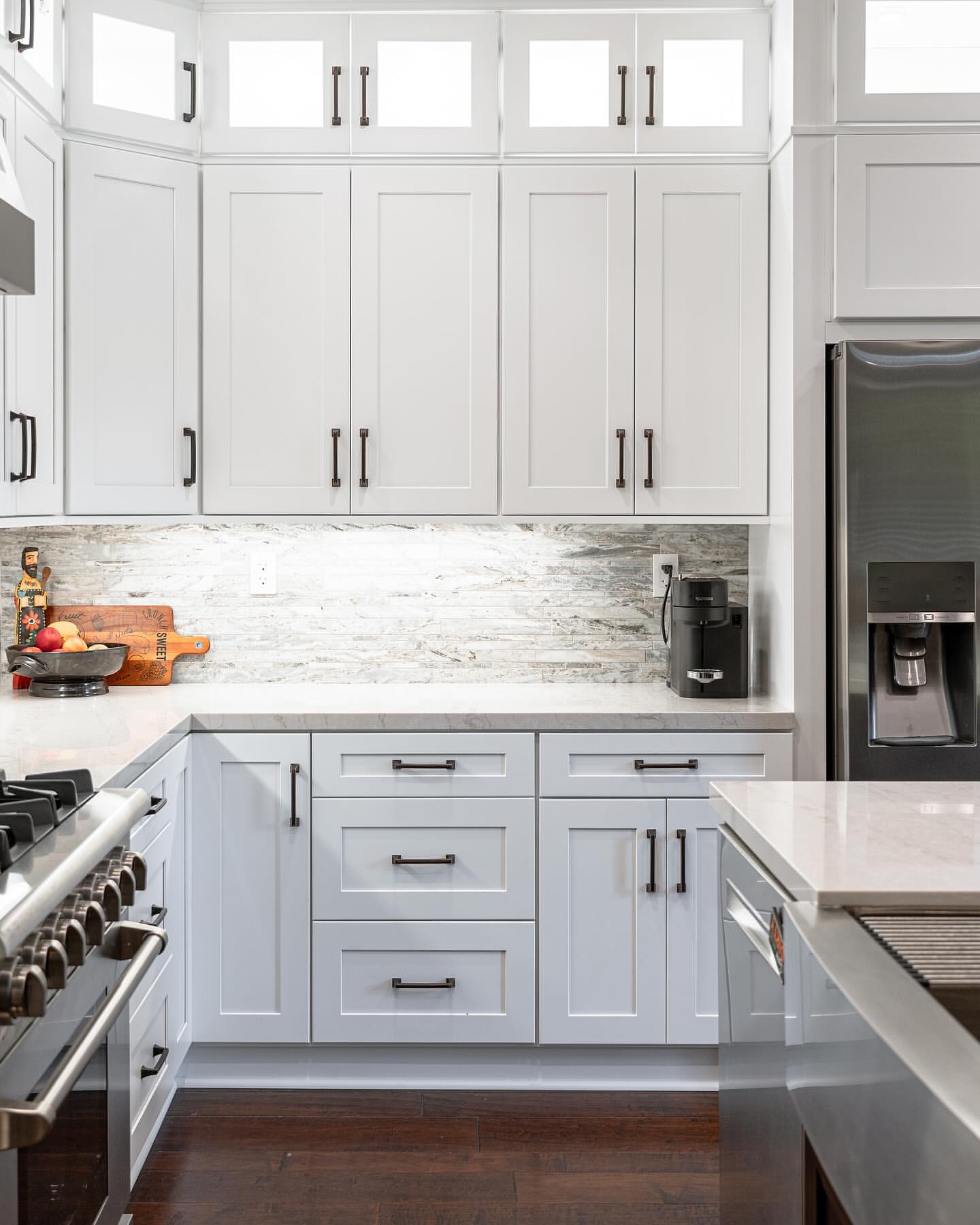 R&B project: white shaker kitchen with glass-front upper cabinets and a stainless range