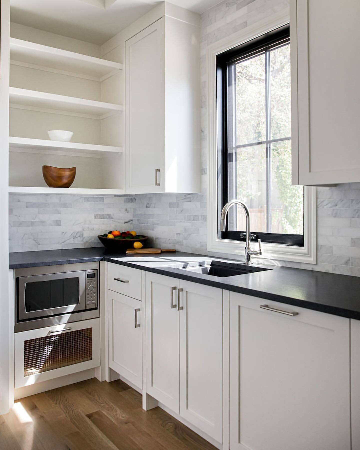 R&B project: white shaker cabinets with open shelves, a black counter and a black-framed window
