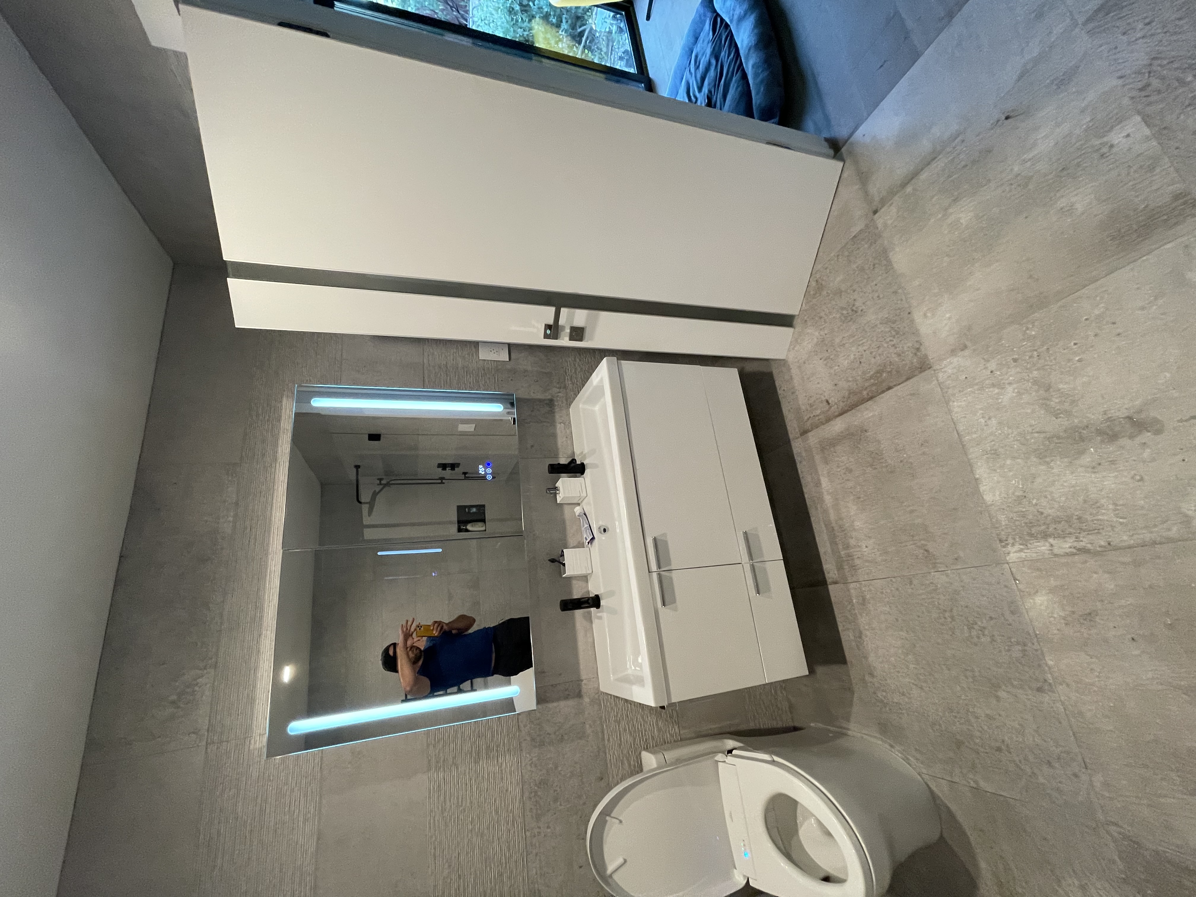 R&B project: floating white vanity with a lit mirror beside a wall-hung toilet