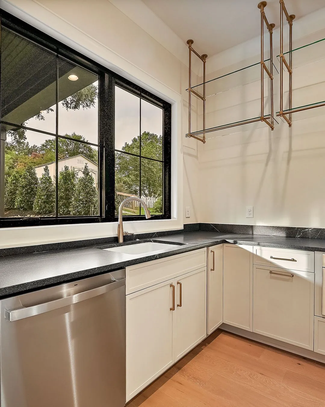 R&B project: kitchen sink under black window with brass hanging rack